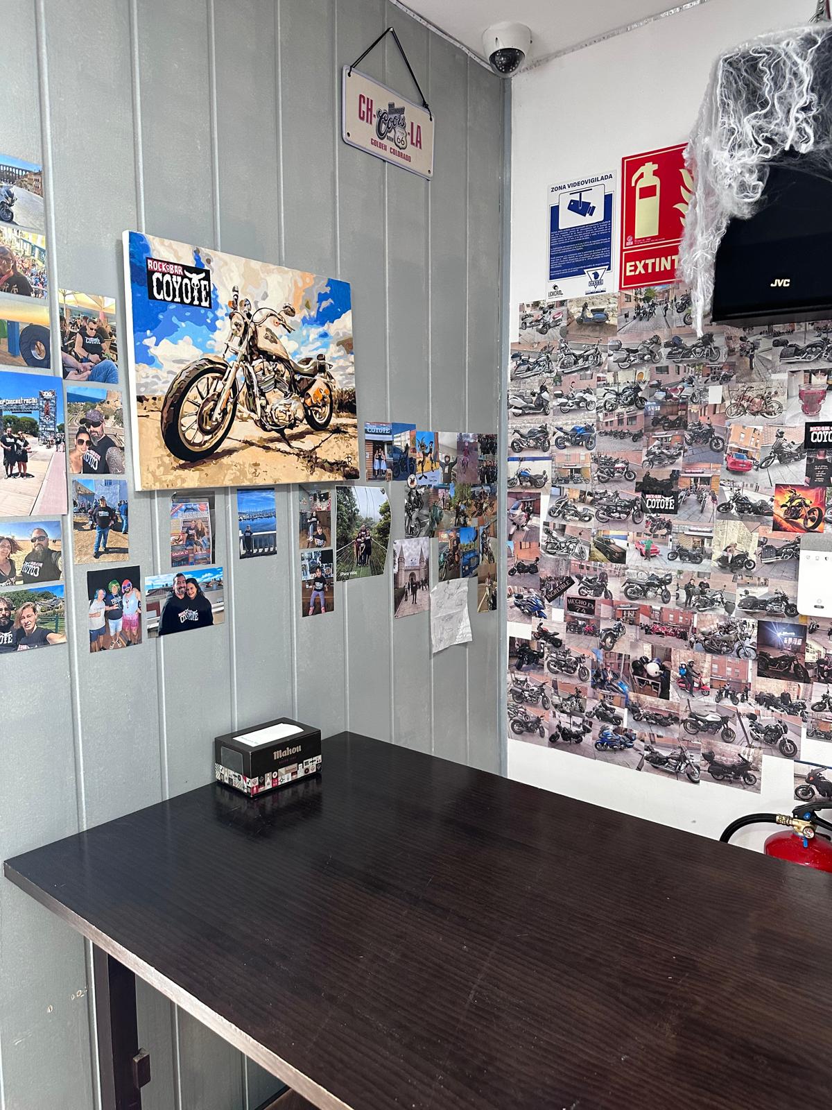 Mesa del Bar Coyote junto a una pared de fotos de clientes