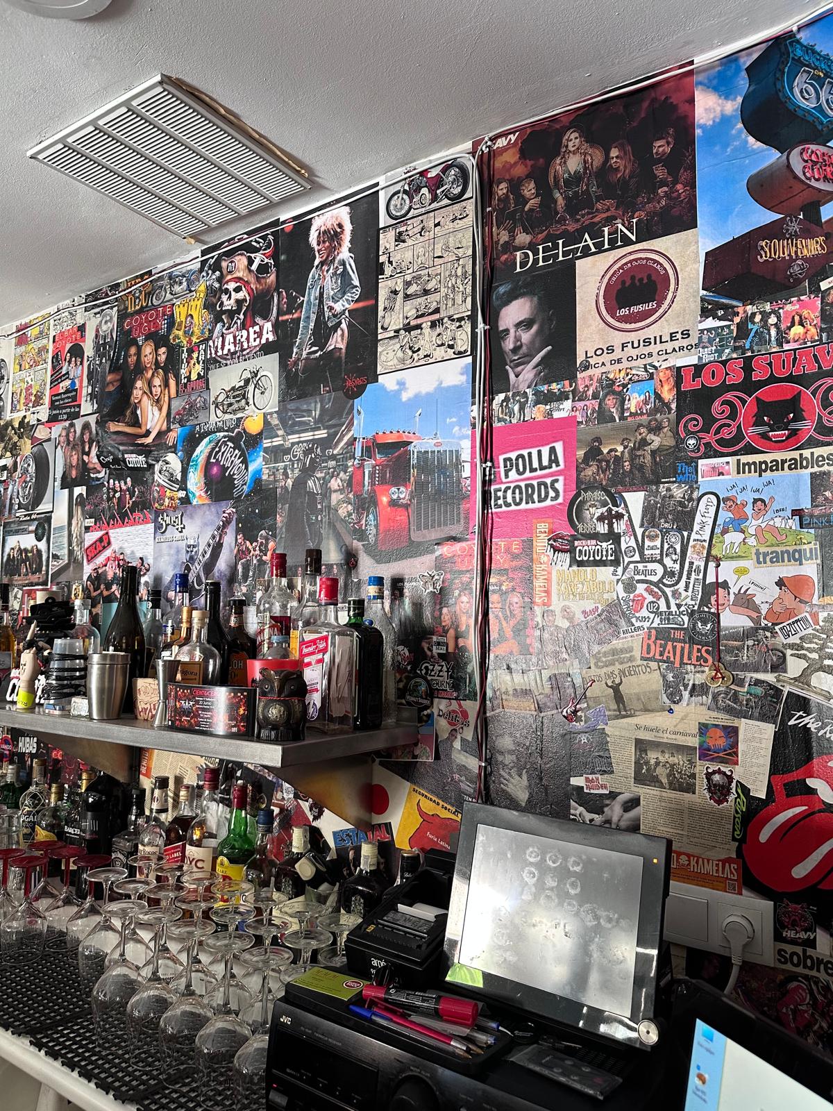 Pared del Bar Coyote cubierta de pósters y pegatinas de rock