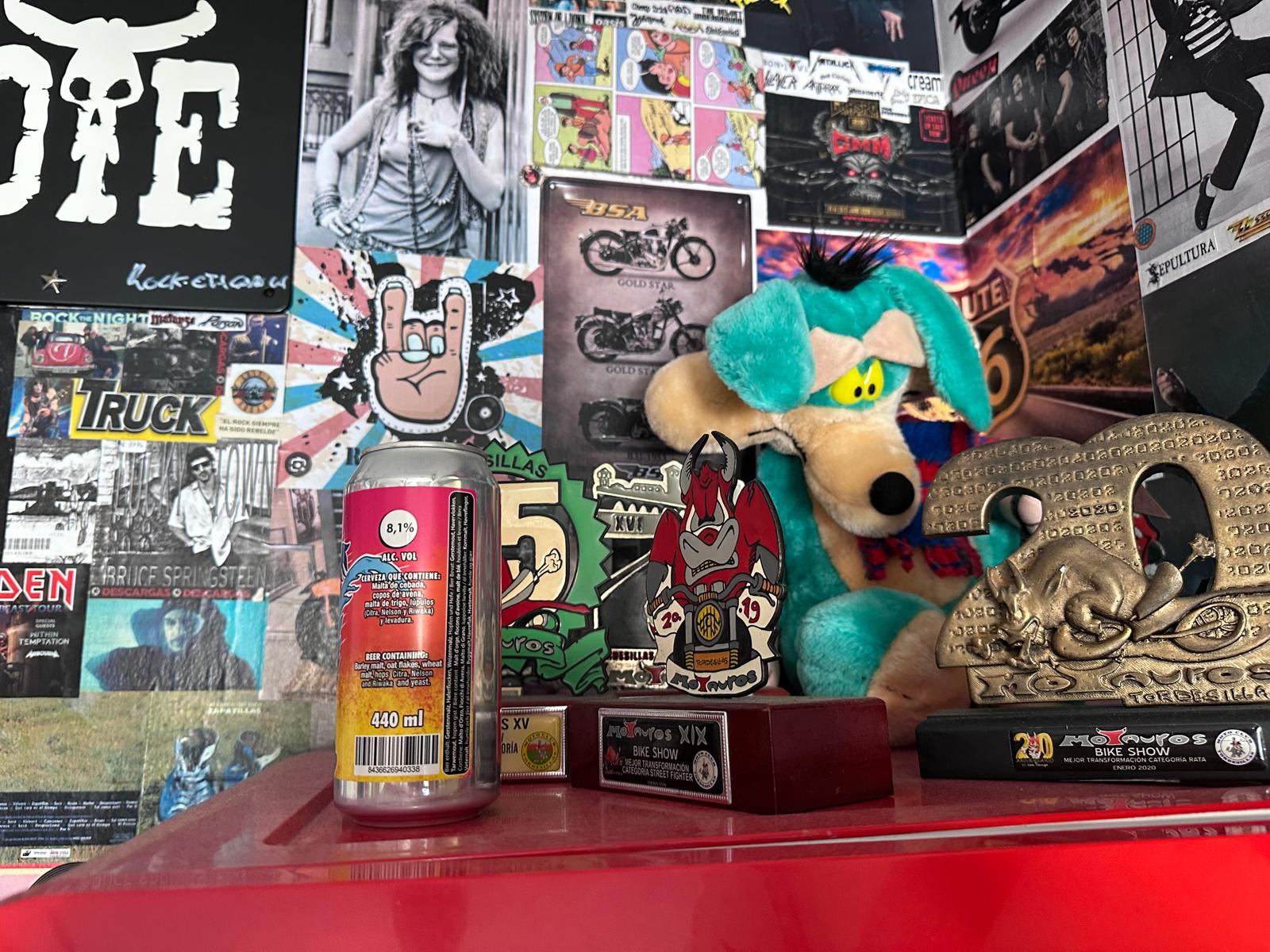 Rincón del Bar Coyote con la mascota coyote, latas y pared de pegatinas rockeras
