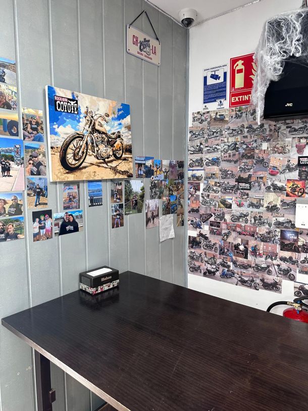 Mesa del Bar Coyote junto a una pared de fotos de clientes